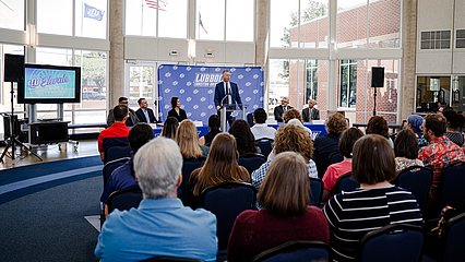 Inside the Rotunda of the Cardwell Welcome center. President Scott McDowell is delivering a speech to several people in seated in the audience.