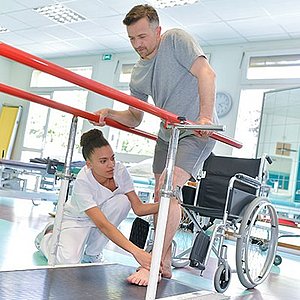 Occupational therapist helping patient to walk