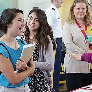 Student standing in front of a booth at a career fair
