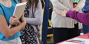 Student standing in front of a table at a career fair