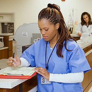female nurse filling out forms at desk