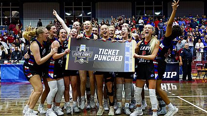 Lady Chaps after regional championship game holding sign that says, "Elite Eight, Ticket Punched"