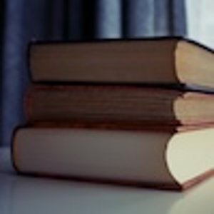 A stack of 3 books on a desk
