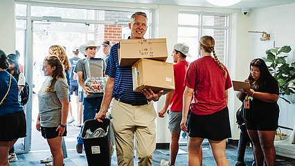 President Dr. Scott McDowell helping move freshmen into the LCU residence halls