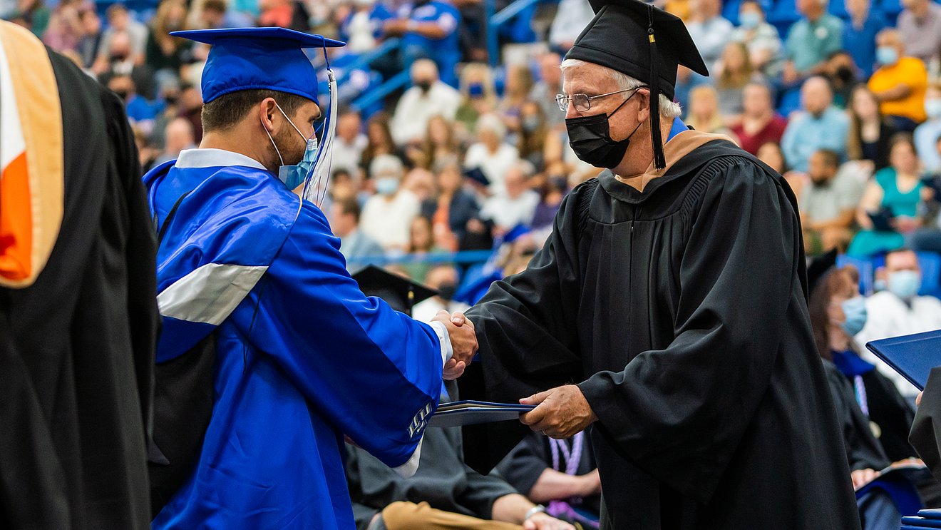 Student receives diploma at Spring commencement