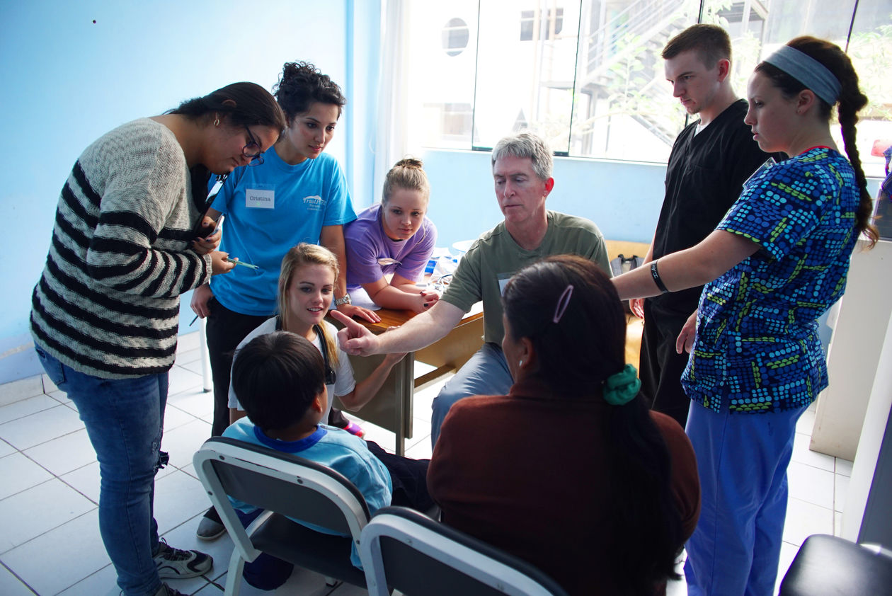 Child having a eye exam done with volunteers observing