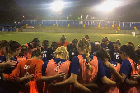 Lady Chaps pray after a match in Costa Rica